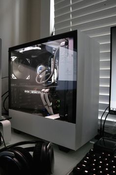 a computer monitor sitting on top of a desk next to a keyboard and headphones