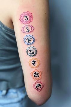 a woman's arm with seven chakras on it