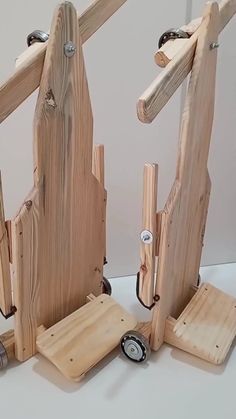 three pieces of wood sitting on top of each other with wheels attached to the sides