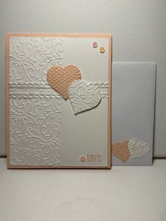 two cards with hearts on them sitting next to each other, one is white and the other has gold