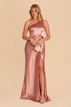 a woman in a long pink dress with one leg slited out and the other side split