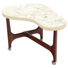 a white marble topped table with wheels on it's legs and a wooden frame