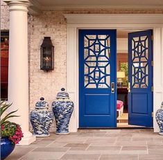 two blue and white vases sitting in front of a door