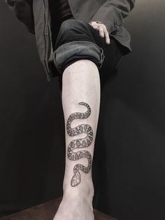 a person with a snake tattoo on their leg