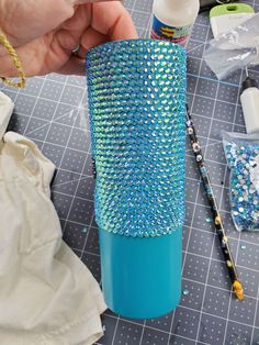 a person is making a vase out of plastic beads and other crafting supplies on a table