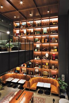 the interior of a restaurant with tables and couches in front of shelves filled with books