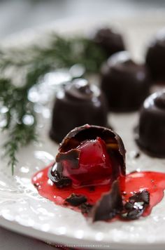 a plate with some chocolates covered in red sauce and drizzled with ketchup