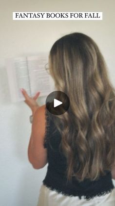 a woman is reading a book with long hair