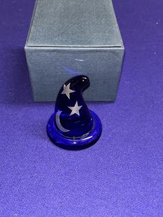 a small blue hat with white stars on it sitting in front of a gray box