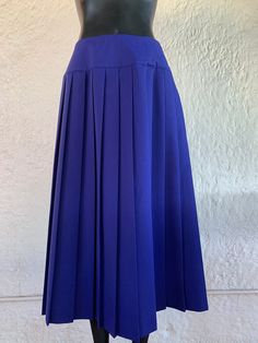 Vintage Mary McFadden pleated yoke skirt with side button closure and one side pocket.  78/22% Polyester/Rayon Measurements lying flat: Waist: 13 inches Length: 31.5 inches Size: 10 This item is in good vintage condition! All items are stored in a smoke-free environment   Lowbrow Vintage is based in Tucson, Arizona, and is an entirely independent and family run business. At Lowbrow Vintage, we focus on curating a unique and funky aesthetic, while still leaving room for comfort and charm. We hope that these wonderful pieces are appreciated once again in the cycle of vintage love. We care deeply about vintage fashion and do our best describe and photograph each item with care and detail. Our pieces are well loved ready and waiting for a new life in the cyclical nature of fashion. Don't hesit Blue Midi Skirt With Accordion Pleats, Blue Relaxed Pleated Skirt With Accordion Pleats, Fitted Blue Bottoms With Accordion Pleats, Blue Full Skirt With Accordion Pleats, Blue Pleated Waist Skirt For Work, Blue Relaxed Accordion Pleated Skirt, Blue Relaxed Fit Accordion Pleated Skirt, Spring Full Length Fitted Pleated Skirt, Spring Blue Skirt With Accordion Pleats