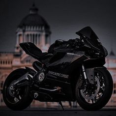 a black motorcycle parked in front of a building with a dome on it's roof