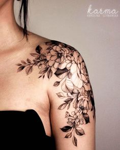 a woman wearing a black dress with flowers on her shoulder and chest tattoo design by karmna