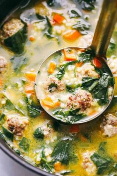 a ladle full of soup with meatballs and spinach