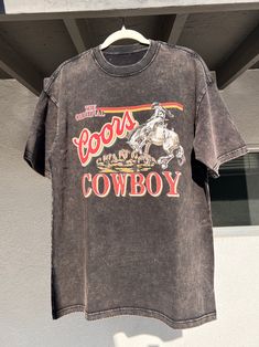 Embrace classic cowboy style with this dusk black vintage washed Coors Cowboy T-shirt. This black T-shirt features a retro Coors design, bringing together rugged Western charm and everyday wearability. Gender: Unisex Model: Regular Fabric: 100% Cotton Fabric Weight: 6.5 oz/yd² (220 g/m²) Fabric Thickness: Moderate Fabric Stretch: Slight stretch Care Instructions: Handwash or machine wash at a maximum temperature of 40℃ (105F) Do not bleach Iron on low heat Regular dry cleaning Tumble dry Feature Retro Stonewashed Summer Tops, Retro Stonewashed Short Sleeve T-shirt, Vintage Stonewashed Relaxed Fit T-shirt, Black Stonewashed Short Sleeve Tops, Retro Stonewashed Cotton Tops, Retro Cotton Stonewashed Top, Vintage Washed Black Stonewashed T-shirt, Black Washed Graphic Tee T-shirt, Vintage Stonewashed T-shirt In Washed Black