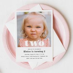 a pink paper plate with a photo of a baby on it and the words two are in white