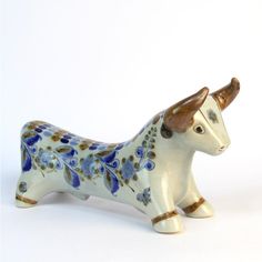 a ceramic cow figurine with blue flowers on it's body and horns