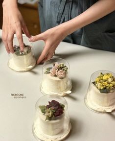 a woman placing flowers on top of a cake in three different tiered cakes,