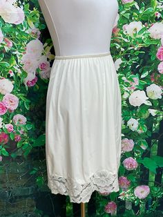 "Vintage 1960's white nylon slip by Lorraine Lingerie. Skirt slip has a white floral lace hem and a lace flower applique in front. Good elastic waist. Size Medium. Nice vintage condition with normal wear. Please see photos for more details. Measurements- Waist-22\"-28\" Hips-Free Length-22\" Slip will be shipped First Class Mail All items are vintage that are preowned and have been worn. All of the items will show some form of wear, tear or odor due to their age. Lingerie is washed before being Vintage Lace Trim Petticoat For Summer, Vintage Spring Petticoat With Lace Trim, Fitted Vintage Cream Petticoat, Vintage White Lace Petticoat, Vintage Lace Trim Slip Dress For Sleep, Nylon Skirt, Cave Creek, Dressing Gown Robe, Lace Slip Dress