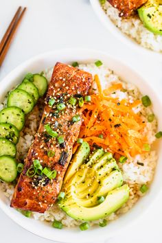 two bowls filled with rice and vegetables on top of a white table next to chopsticks