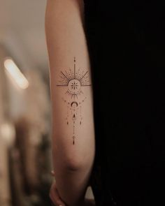 a woman's arm with a compass tattoo on the left side of her arm