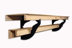 a wooden shelf with two black brackets on the top and one is attached to it