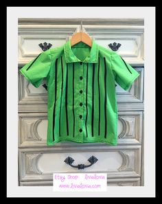 a green shirt is hanging on a dresser