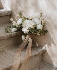 a bouquet of white flowers sitting on some steps