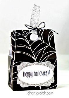 a black and white halloween treat box with a spider web design on the front that says happy halloween