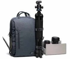 a camera and tripod are sitting next to each other in front of a backpack