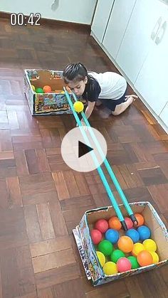 a little boy playing with some balls on the floor