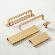 four pieces of brass furniture on a white surface