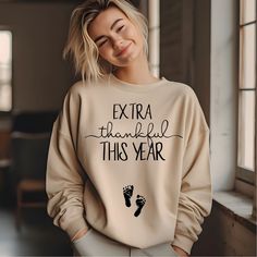 a woman wearing a sweatshirt that says extra thankful this year