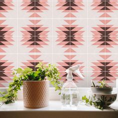 a window sill with plants and a spray bottle on it next to a tiled wall