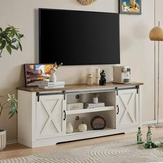 a flat screen tv sitting on top of a wooden entertainment center in a living room