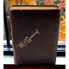 a brown book sitting on top of a window sill