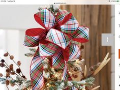 a christmas tree decorated with red, white and green plaid bows in a wooden box