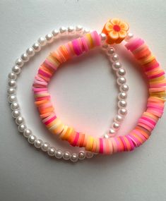 two bracelets with flowers and pearls on them