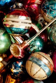 a pile of christmas ornaments with different colors and sizes