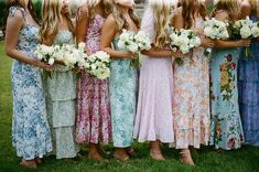 a group of women standing next to each other holding bouquets