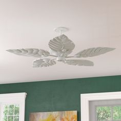 the ceiling fan is hanging from the ceiling in the room with green walls and white trim