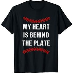 a t - shirt that says my heart is behind the plate with baseball stitches on it