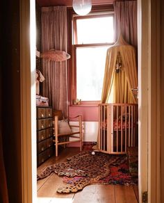 an open door leading to a baby's room with a crib in the corner