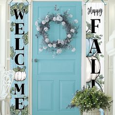 a blue door with a welcome sign next to it and a wreath on the front door