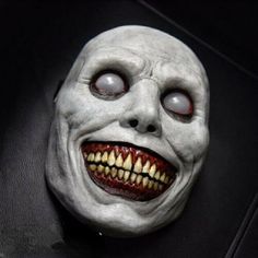 a creepy mask with red eyes and teeth