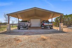 two trucks are parked in front of a carport