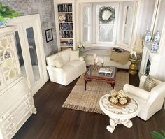 a living room filled with white furniture and lots of wood flooring next to a window