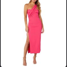 a woman wearing a pink dress with one shoulder and slited leg, posing for the camera