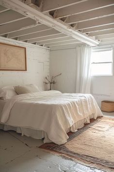 a white bed sitting under a window next to a rug