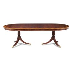 an oval dining table with two pedestals on each side and one end in the middle