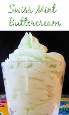 a glass filled with white frosting on top of a colorful table cloth and the words swiss mint buttercream